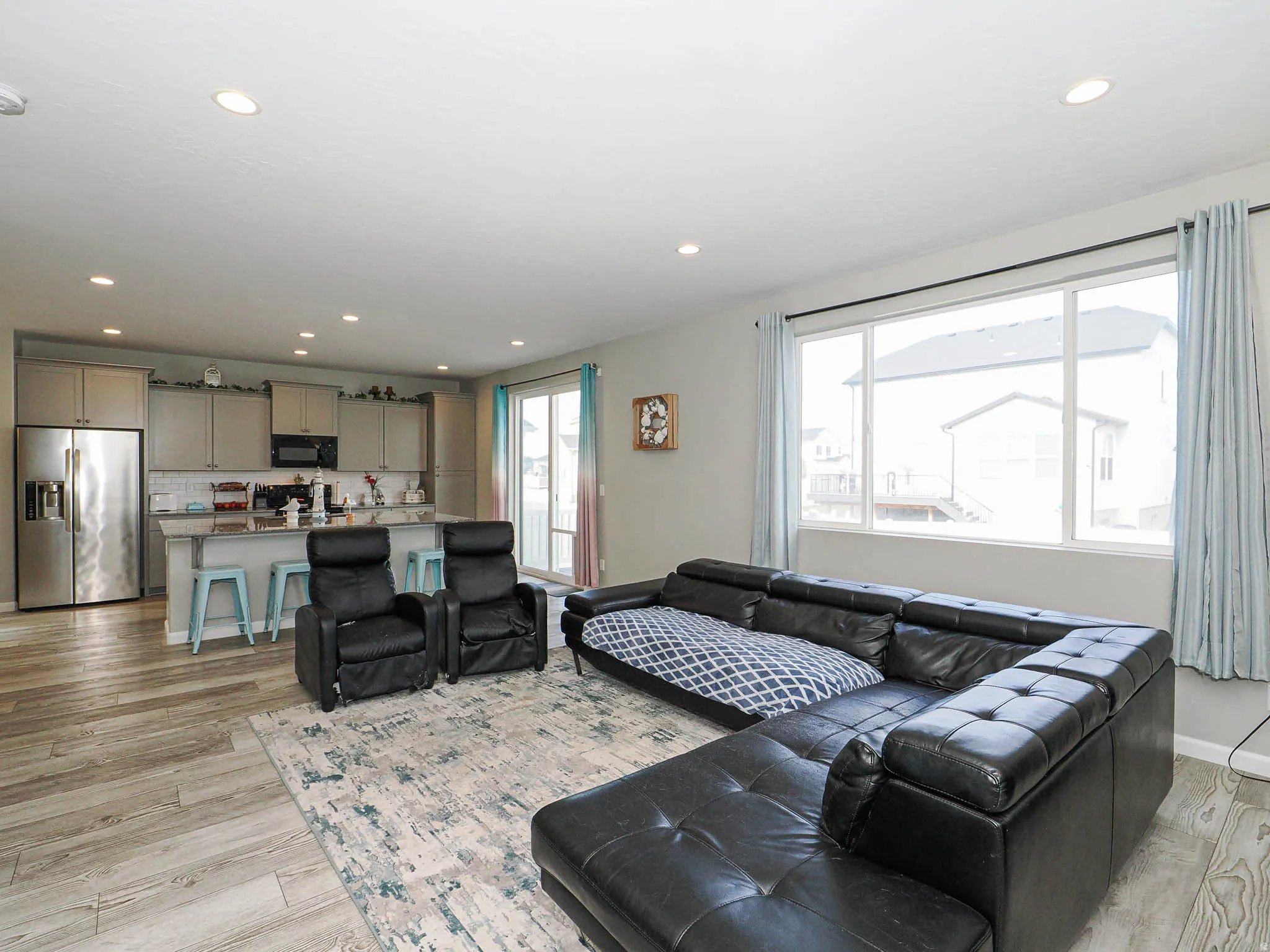 Open-concept living area featuring wood-finish flooring and recessed ceiling lights