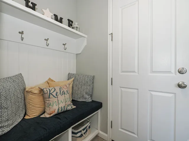 Built-in hall tree with a bench seat, upper shelf, and coat hooks