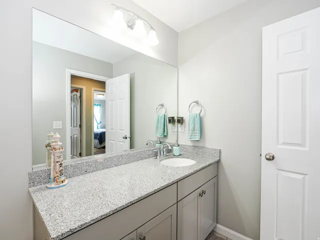 Bathroom vanity featuring a speckled countertop, integrated sink, and brushed nickel faucet