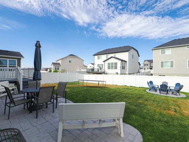Expansive backyard featuring a concrete patio, a distinct circular concrete pad, and a privacy fence