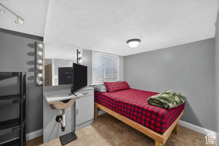 Room featuring wood-finish flooring, neutral gray walls, and a built-in vanity with an integrated sink