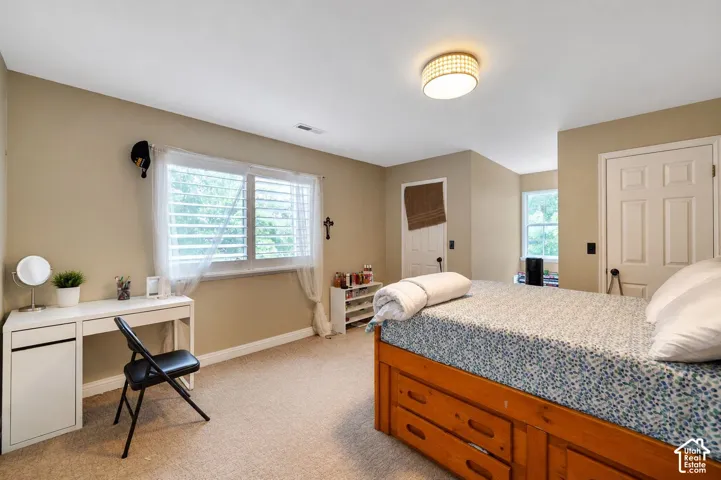 Recessed lighting fixture, plush carpet flooring, multiple windows with natural light, two panel interior doors, and neutral wall tones