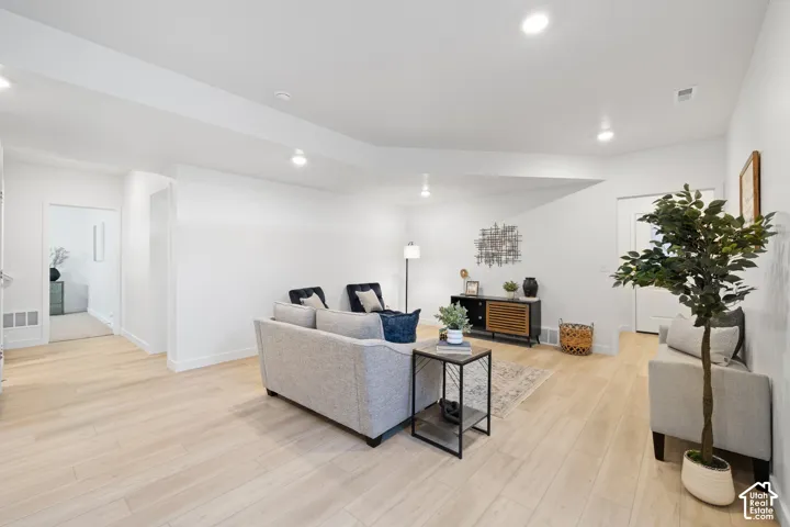 Open-concept ADU living space featuring light wood-finish flooring, recessed lighting, white baseboards, and neutral wall tones