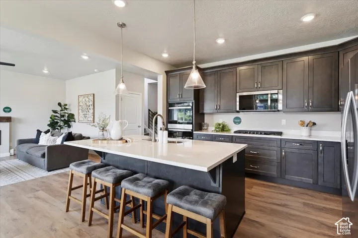Spacious kitchen featuring dark wood-finish cabinetry, light-toned countertops, and stainless steel appliances