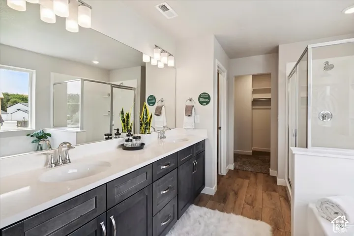 Primary bathroom featuring dual vanity with white undermount sinks and dark wood-finish cabinetry