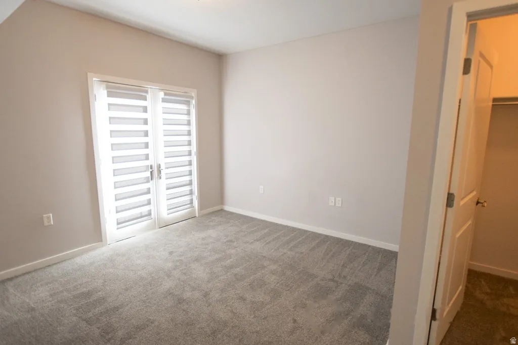Spacious room with plush gray carpeting and light gray wall paint