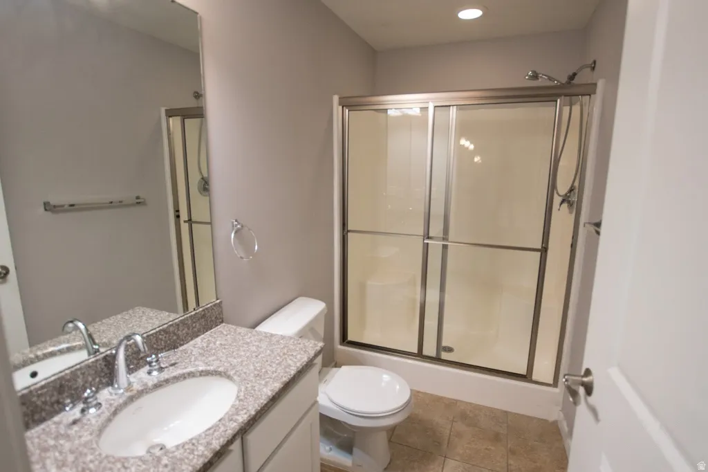 Bathroom featuring a vanity with an undermount sink, a speckled countertop, and a large wall mirror