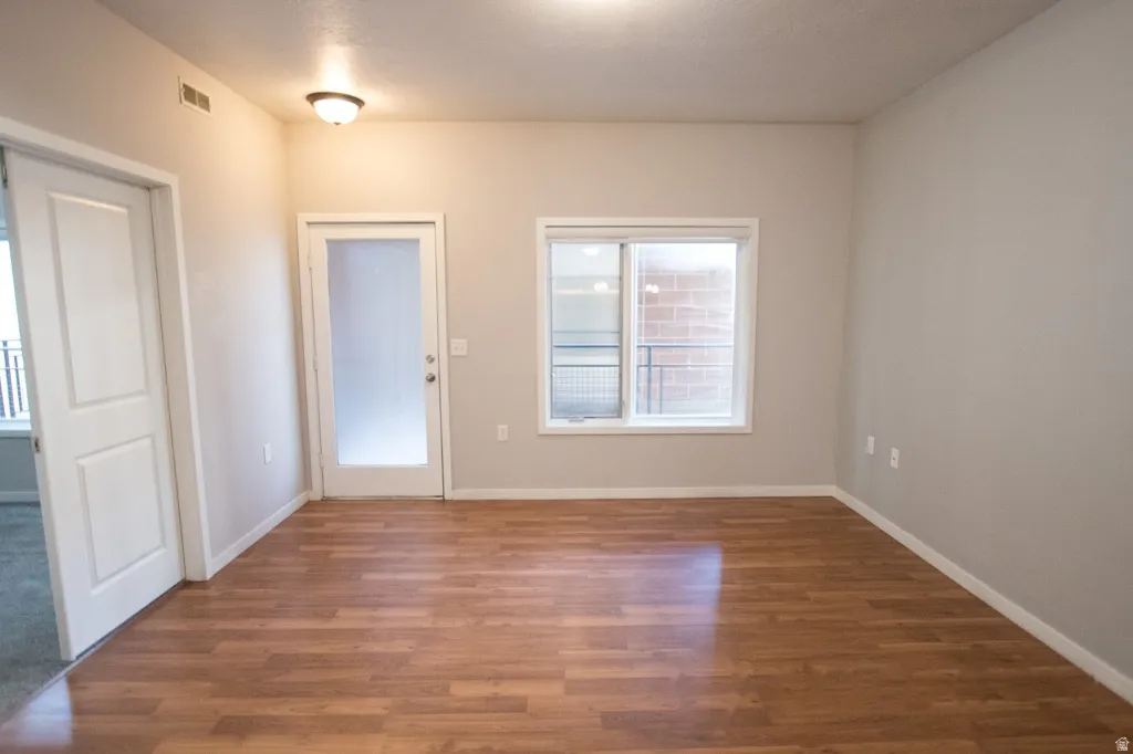 Wood-finish flooring throughout, featuring a frosted glass panel door and a double-pane window