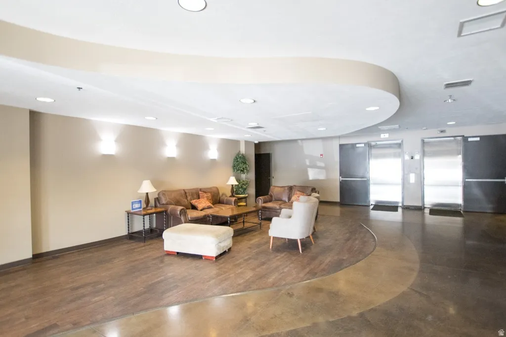 Lobby area featuring mixed wood-finish and polished concrete flooring, recessed lighting, and curved ceiling architectural details