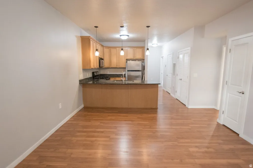 Open-concept living space with wood-finish flooring extending into the kitchen