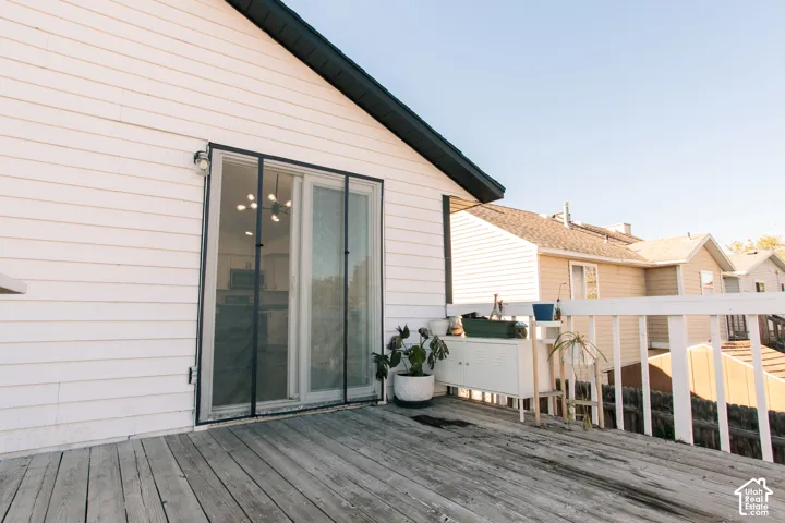 Exterior wood decking with a white railing and white horizontal siding