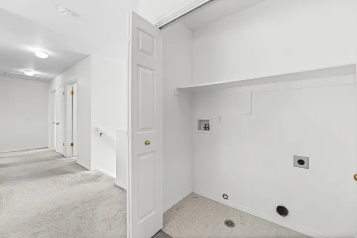 Dedicated laundry area featuring a utility sink connection, dryer vent, and upper storage shelf