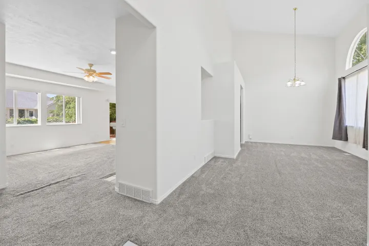 Spacious interior featuring neutral carpeting and high ceilings