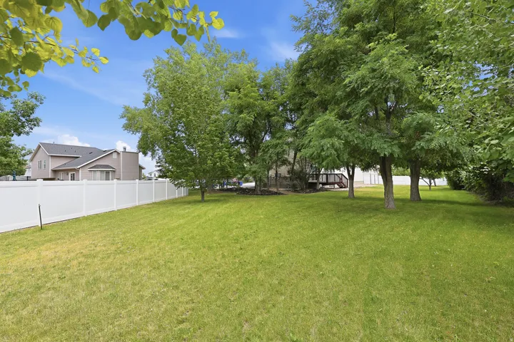 Expansive green lawn framed by a white vinyl fence