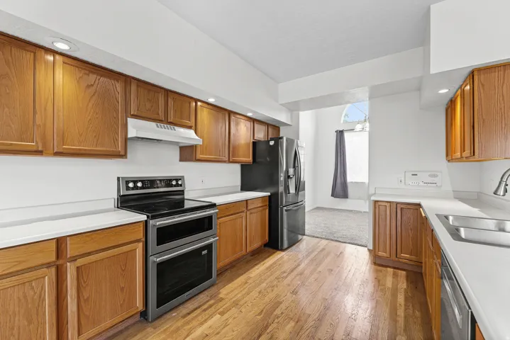 Kitchen featuring wood-finish flooring, recessed lighting, and light wood cabinetry with white countertops