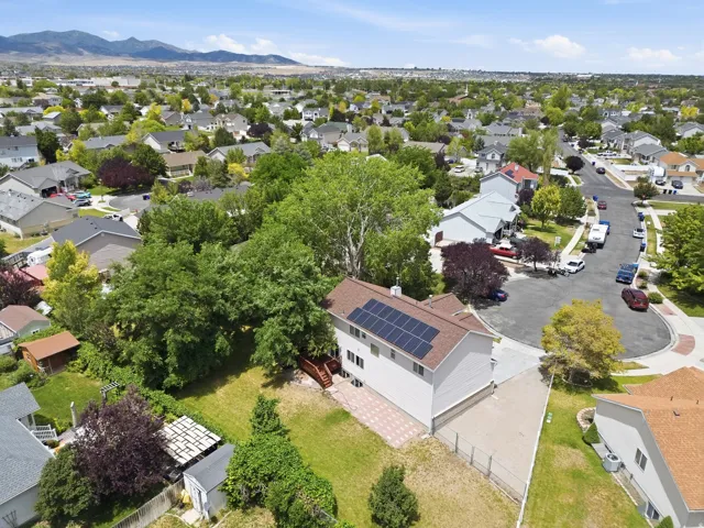 Residential property with solar panel array, attached garage, and a rear deck