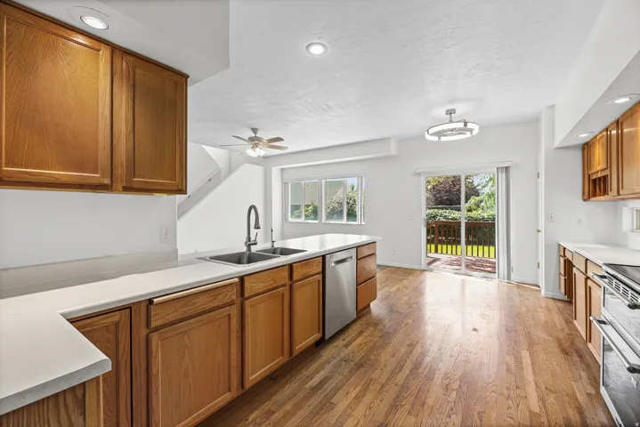 Kitchen featuring wood-finish cabinetry, light-toned countertops, and wood-finish flooring