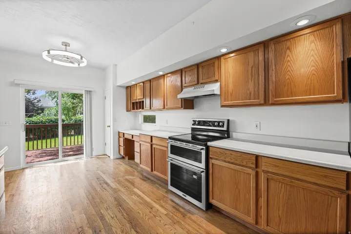 Kitchen featuring wood-finish flooring, recessed lighting, wood cabinetry, and white countertops