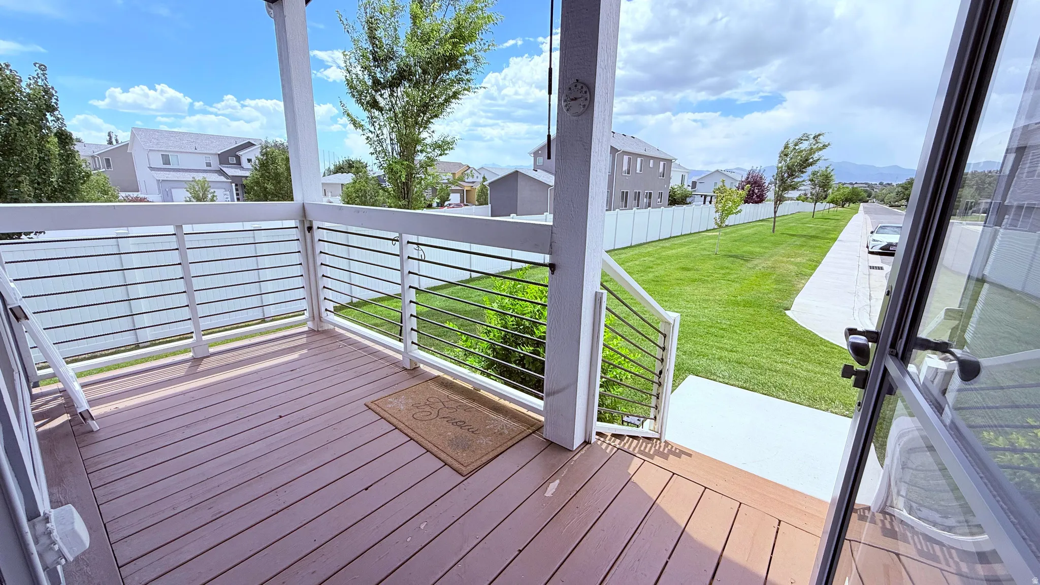 Covered porch featuring decking and white railings with horizontal metal balusters