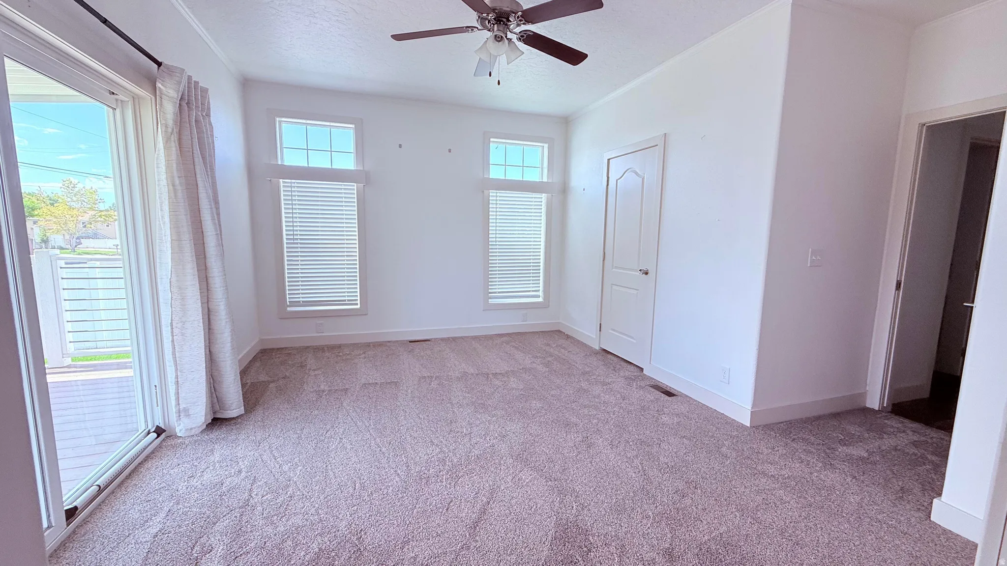 Primary Bedroom with brand new carpet, access to back covered deck and yard