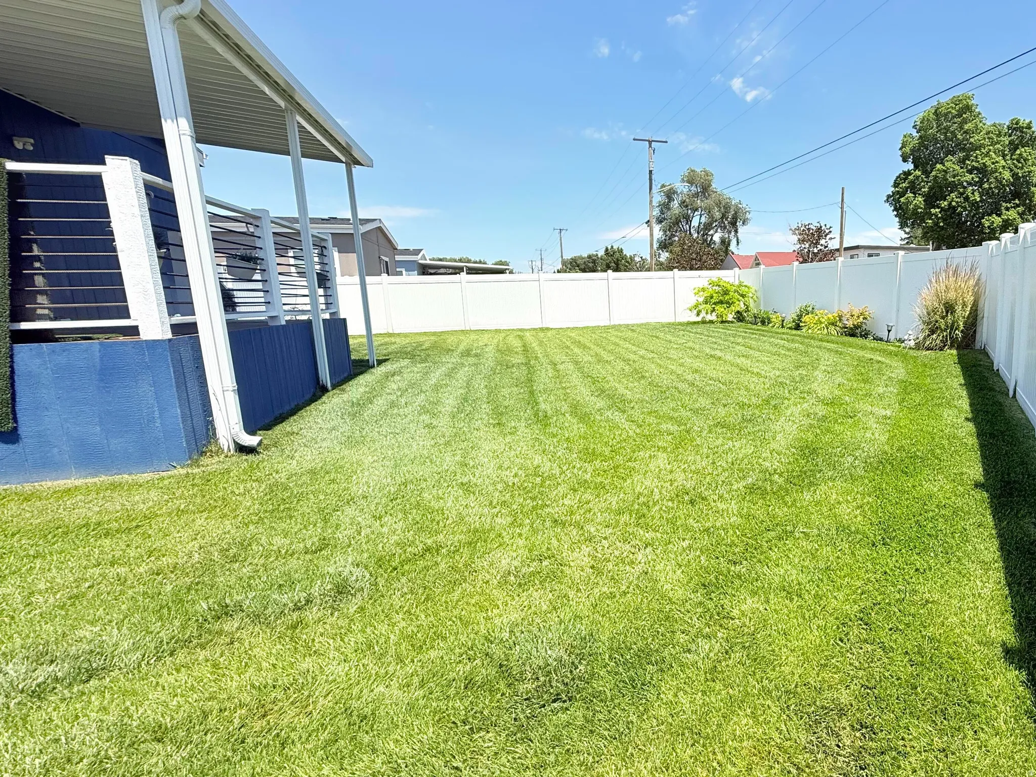 Expansive grassy yard with a full privacy fence