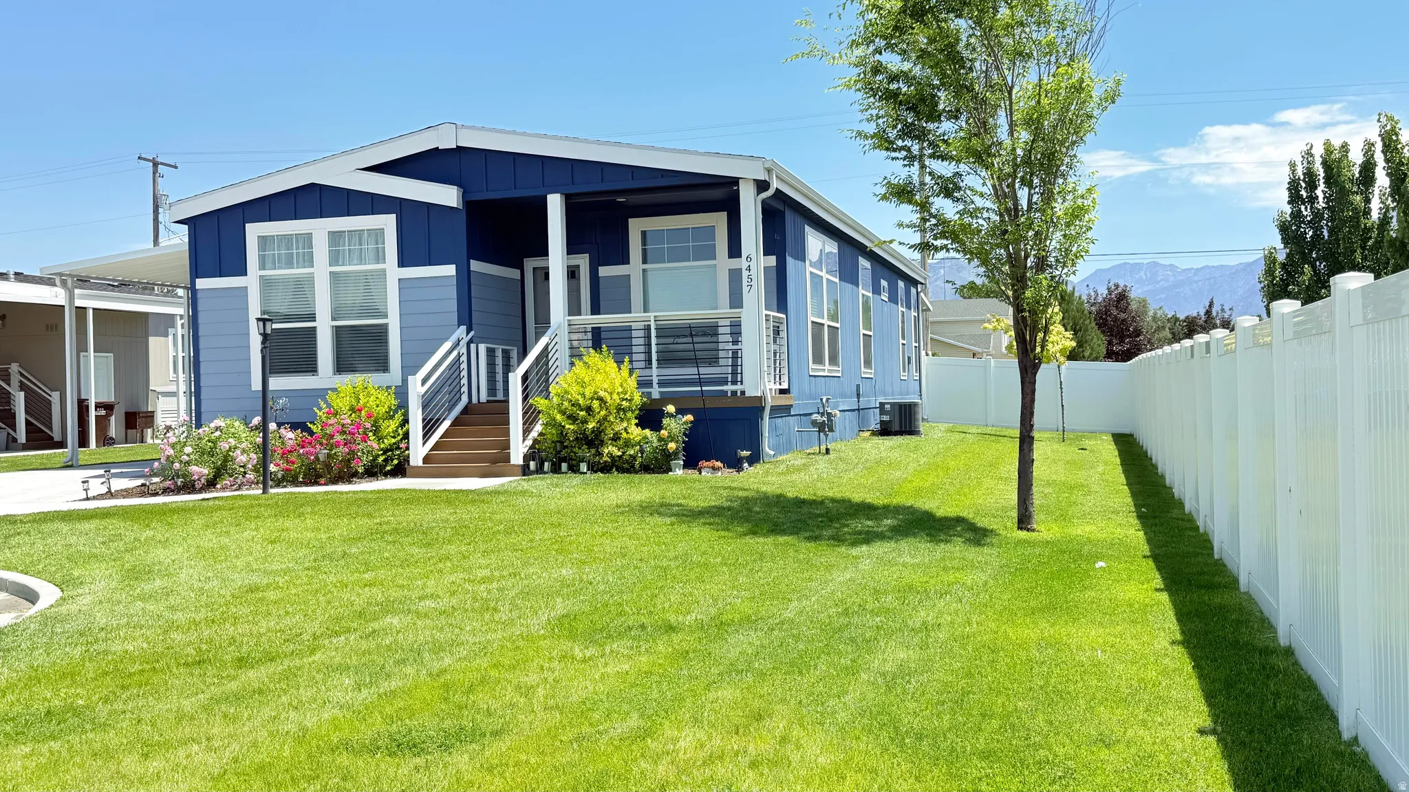 Exterior featuring a two-tone blue siding with white trim, a covered porch entry, and a white railing
