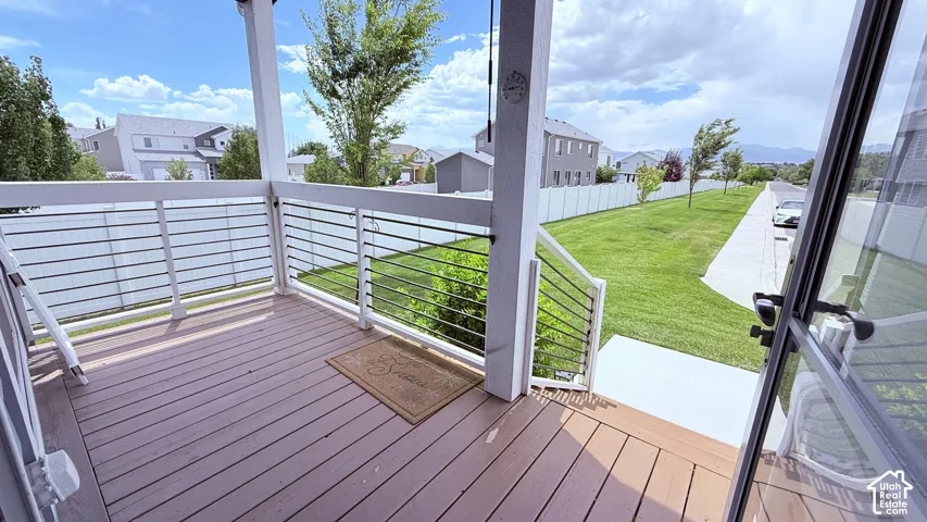 Covered porch featuring decking and white railings with horizontal metal balusters