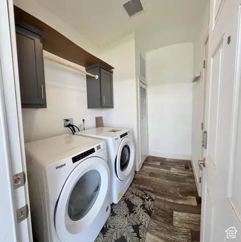 Dedicated laundry space featuring built-in wall cabinetry, and a clothes hanging rod