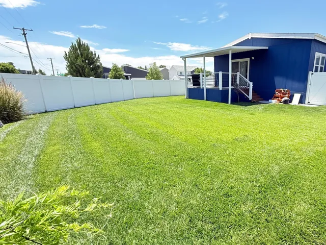 Expansive green lawn with full perimeter fencing