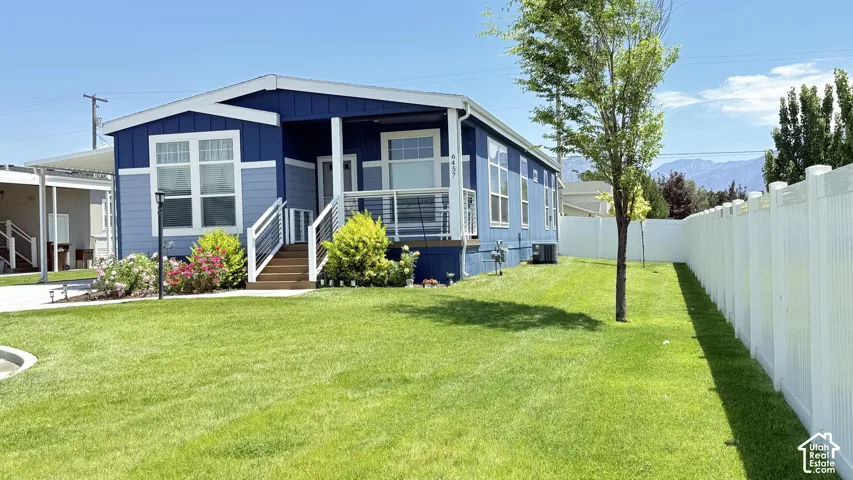 Exterior featuring a two-tone blue siding with white trim, a covered porch entry, and a white railing