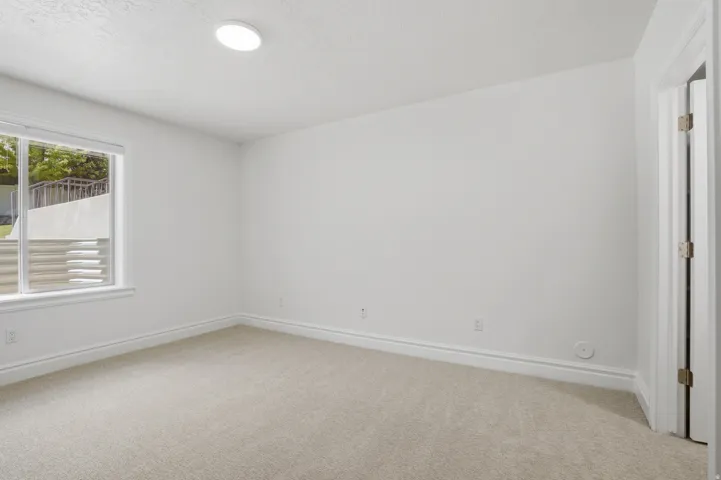 Recessed ceiling light illuminating a carpeted room with white walls
