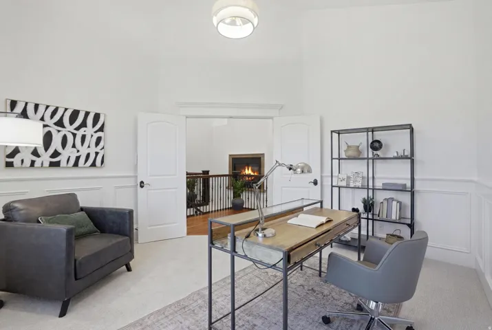 Bright room featuring high ceilings and white wainscoting