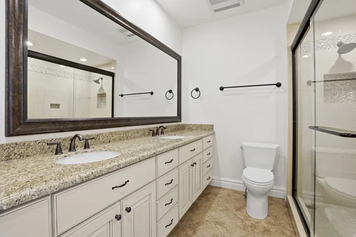Dual sink vanity with stone-finish countertop and dark bronze fixtures