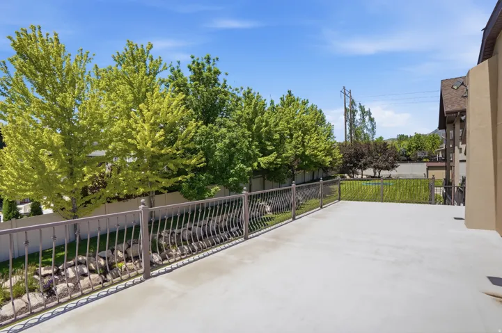 Expansive outdoor deck featuring a decorative metal railing and a large concrete surface