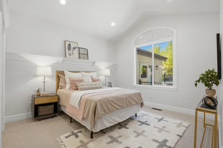 Vaulted ceiling bedroom featuring an arched window, recessed lighting, wall molding, and neutral carpeting