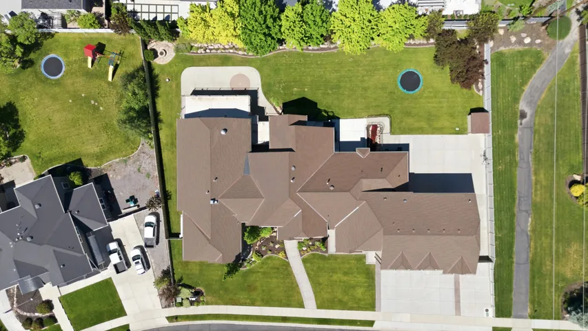 Expansive property featuring a multi-gabled roofline, concrete driveway, and a large manicured lawn