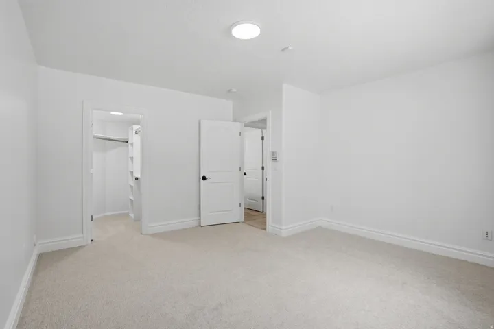 Room featuring light-toned carpeting, white walls, and a recessed ceiling light