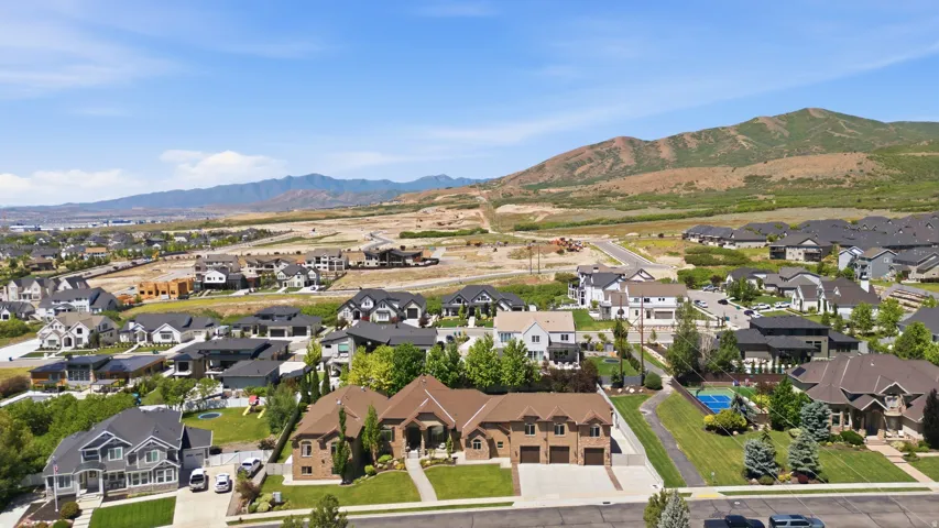 Expansive community featuring diverse architectural styles, mature landscaping, and a mountainous backdrop