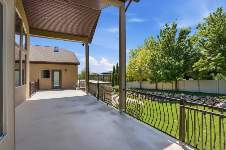 Expansive covered patio featuring recessed lighting, a concrete surface, and decorative metal railings