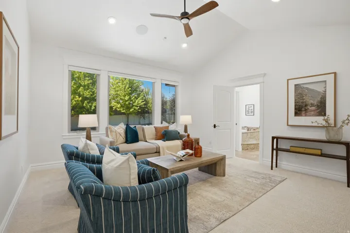 Bright living area featuring vaulted ceilings, recessed lighting, and a wood-finish ceiling fan