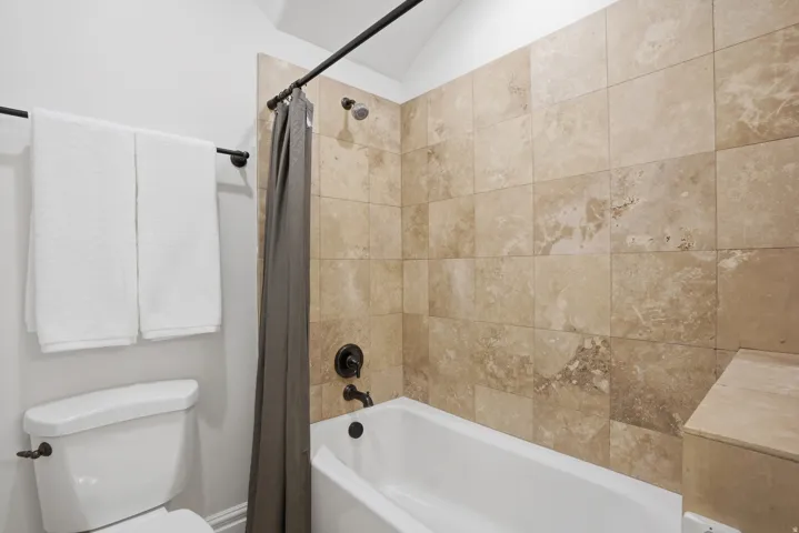 Bathtub and shower combination featuring extensive tile surround