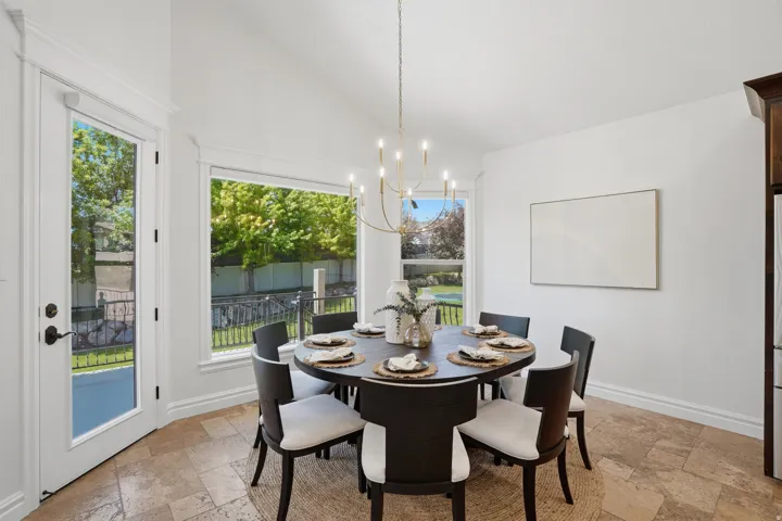 Dining area featuring vaulted ceilings and a modern chandelier
