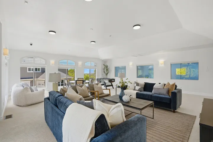Expansive living area featuring carpeted flooring and vaulted ceilings