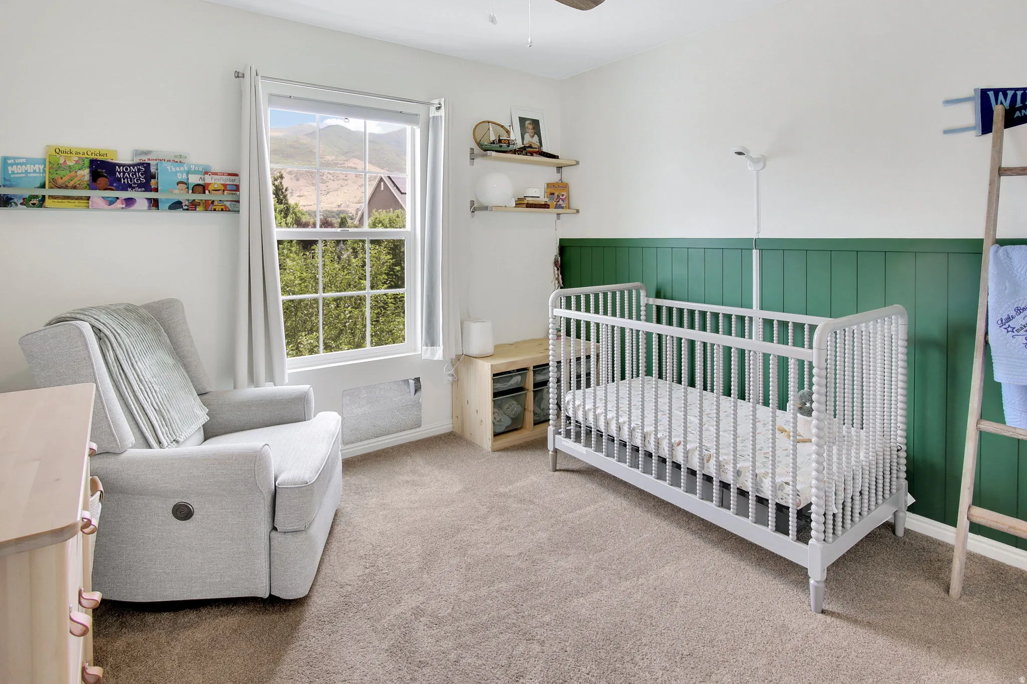 Bedroom featuring white walls and a green wainscoting accent wall