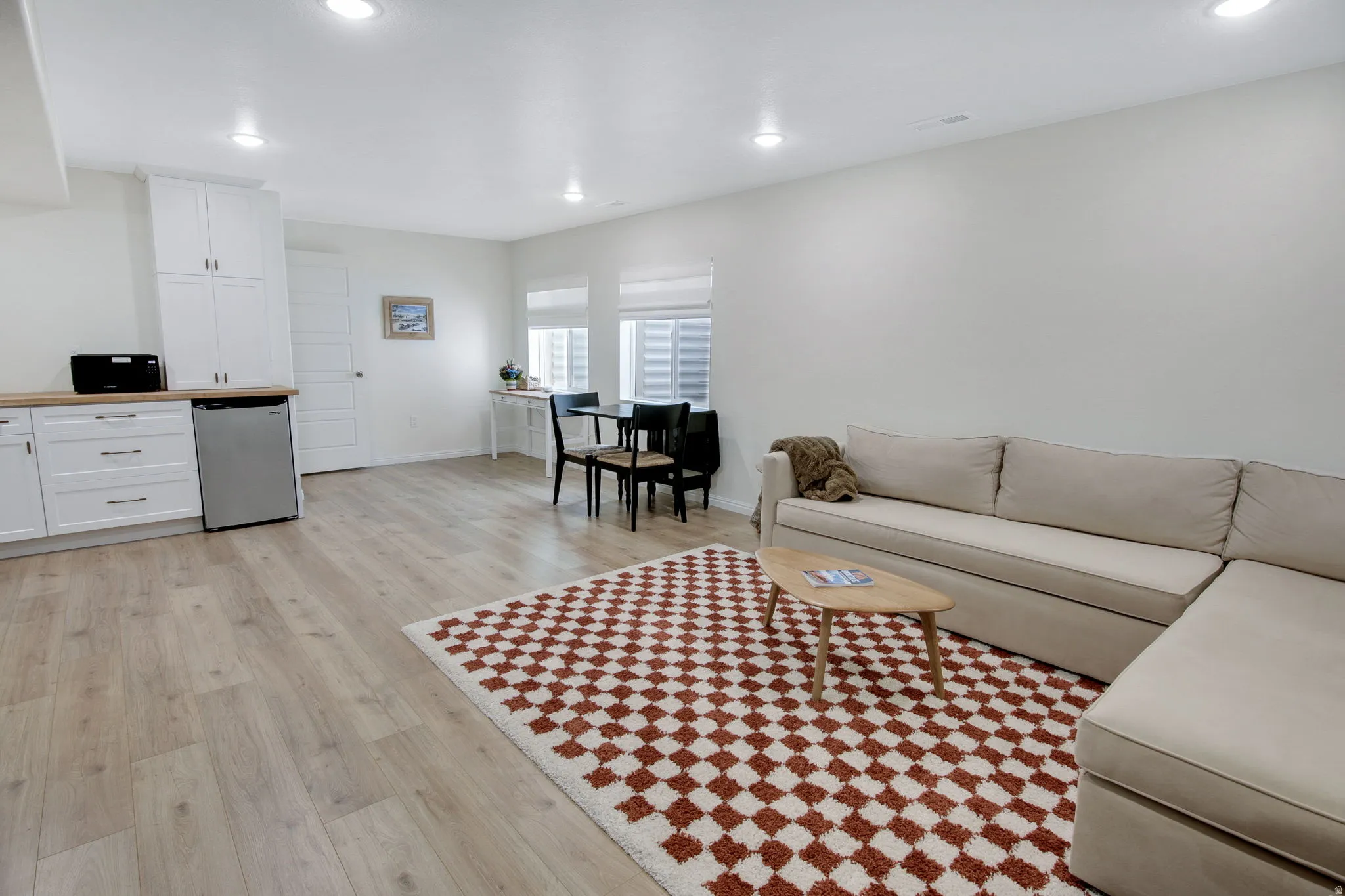 Open-concept living area featuring wood-finish flooring, recessed lighting, and white walls