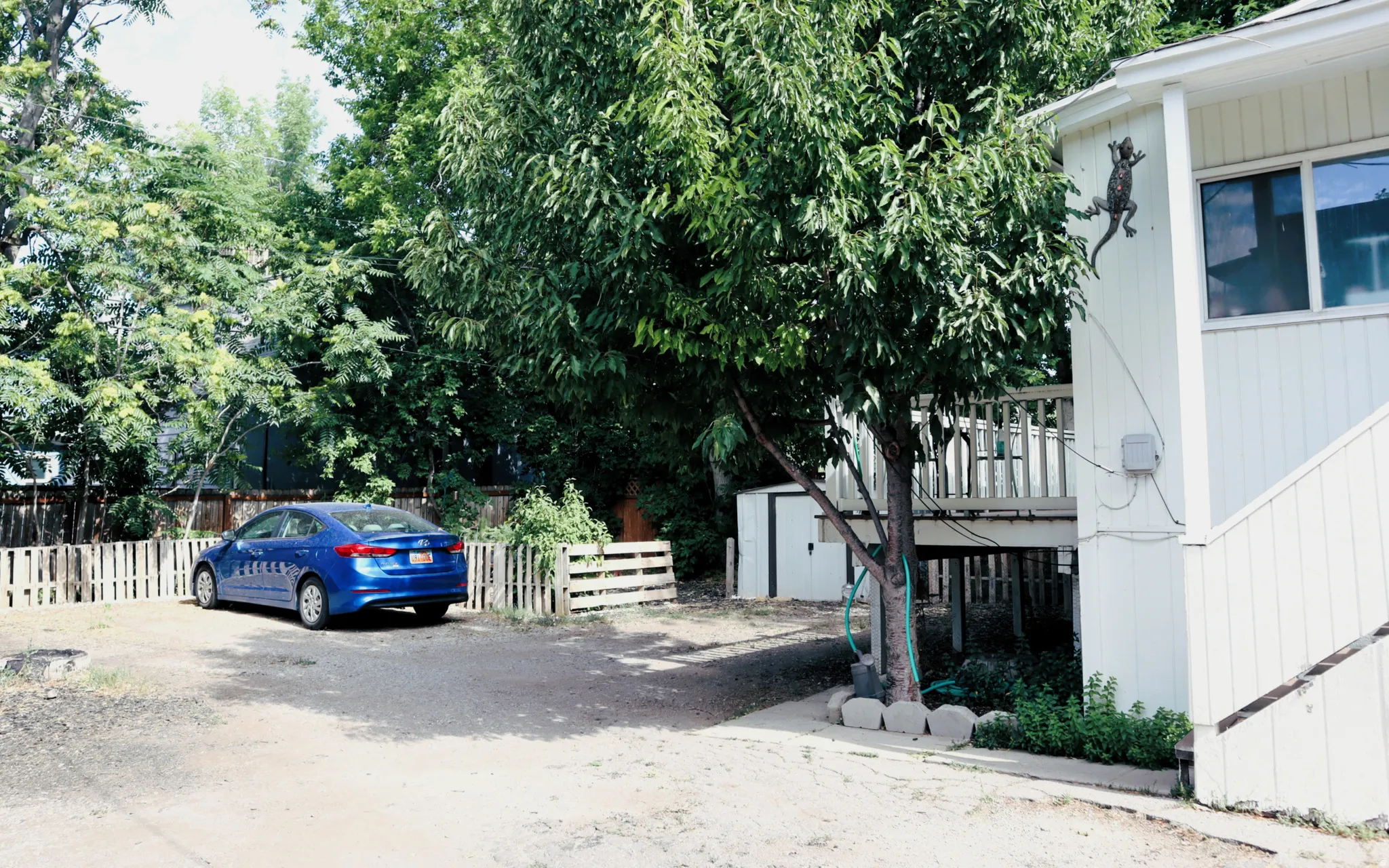 Exterior features include a multi-level deck, white siding, and an outdoor storage shed