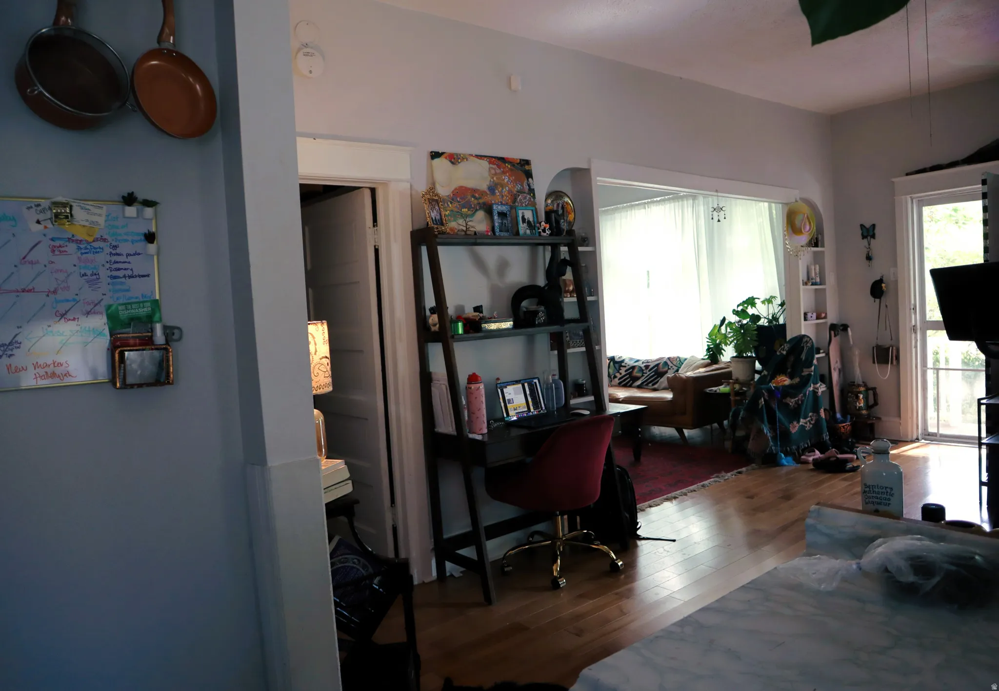 Open floor plan featuring wood-finish flooring, light grey walls, and a large arched entryway