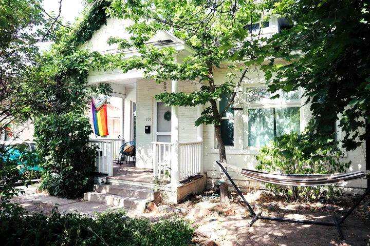 Classic white brick exterior with a welcoming covered front porch, featuring white railings and steps