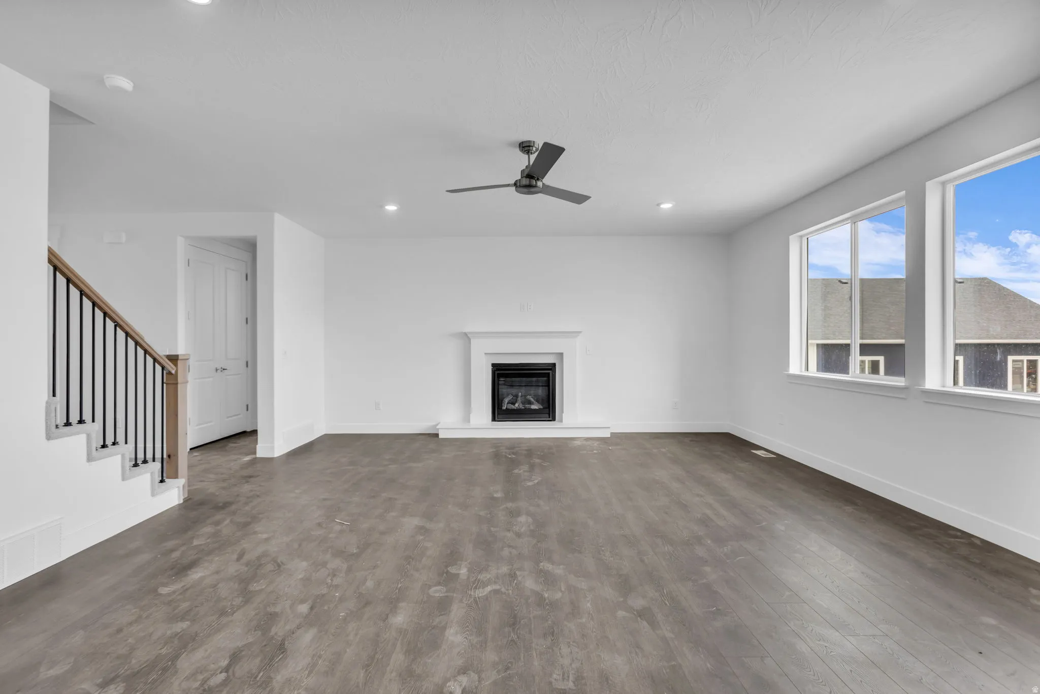 Spacious great room featuring gas fireplace and hard flooring throughout the main floor.
