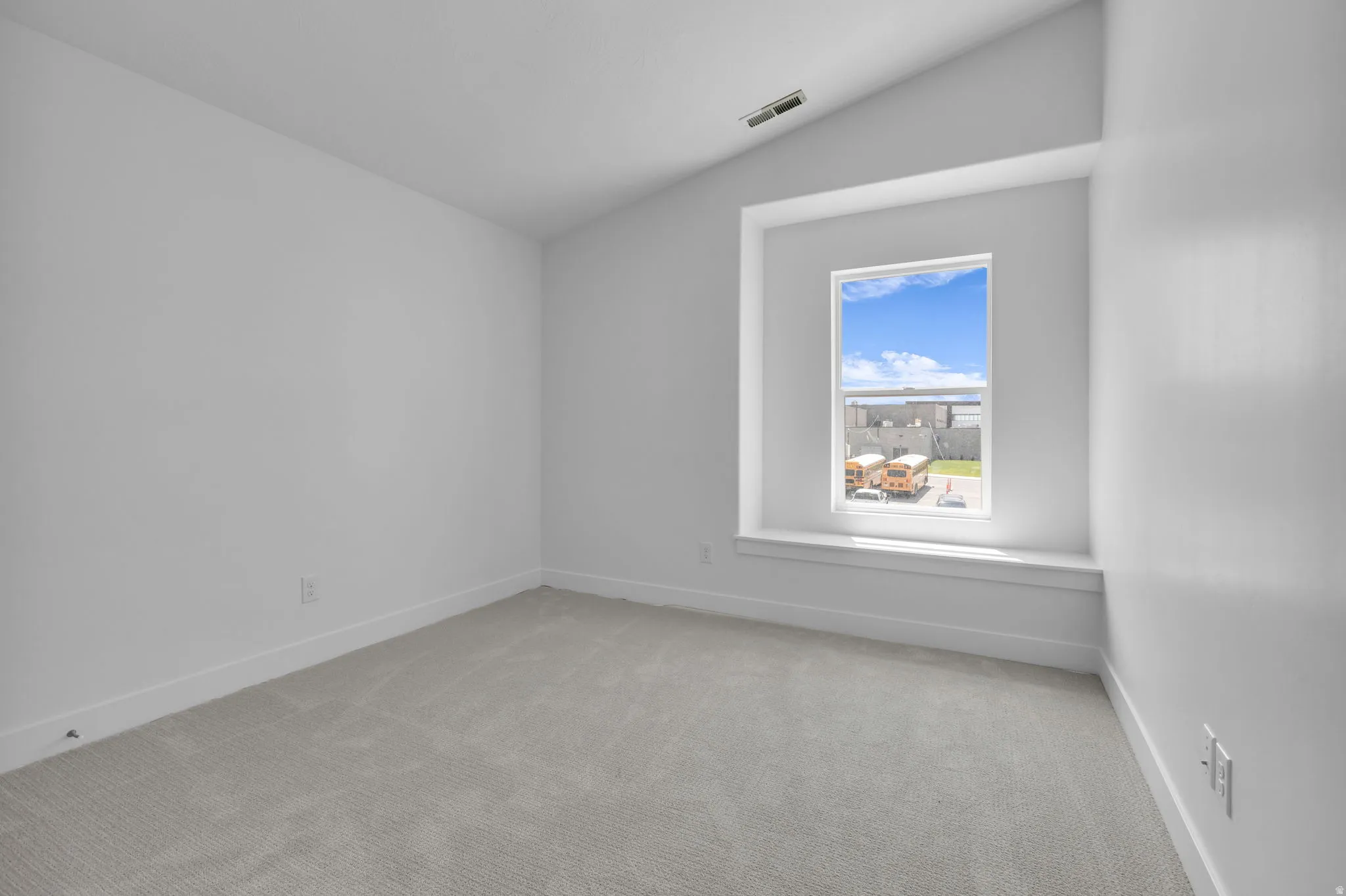 Vaulted bedroom #3 featuring a deep-set window seat and large window.